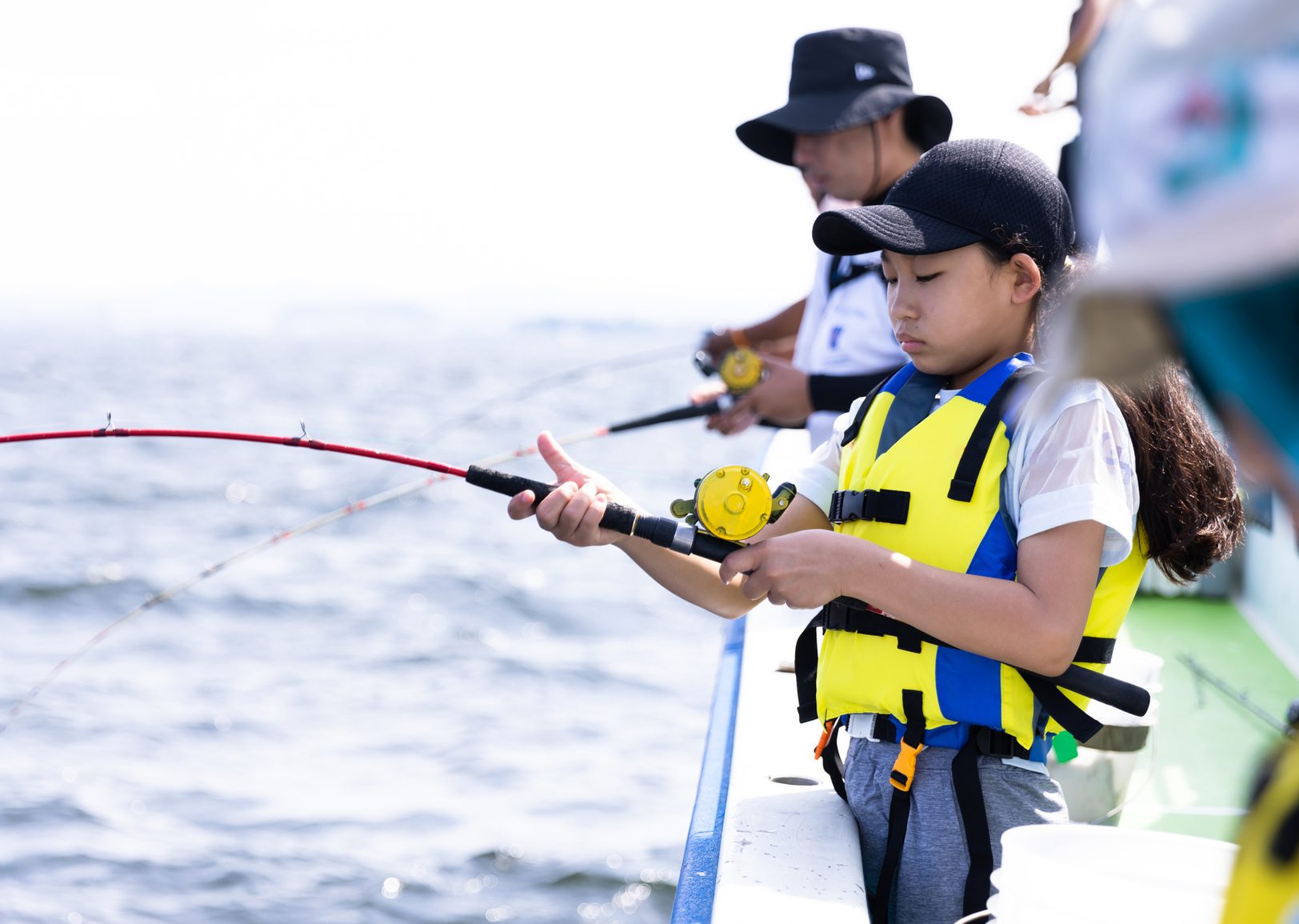 ライフジャケットを着て釣りをする子ども